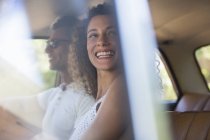 Feliz mujer moderna cabalgando en coche con novio - foto de stock