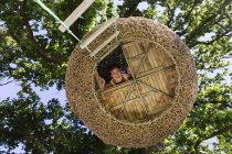 Женщина улыбается в современном домике на дереве — стоковое фото