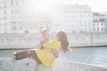 Man holding girlfriend along Seine River, Paris, France — Stock Photo