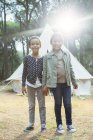 Girls smiling by teepee at campsite — Stock Photo