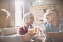 Lächelnde Freunde stoßen im Restaurant auf Bier und Weingläser an — Stockfoto