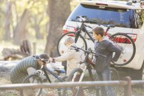 Pai e filhos descarregando bicicletas de carro — Fotografia de Stock
