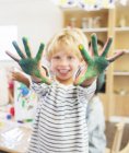 Student showing off messy hands in classroom — Stock Photo