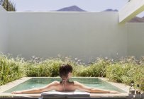 Woman relaxing in luxury lap pool — Stock Photo