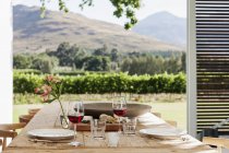 Dining table and chairs on luxury patio overlooking vineyard — Stock Photo