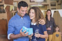 Happy beautiful couple opening gift together — Stock Photo