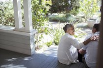 Couple aîné étreignant sur le porche — Photo de stock