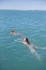 Coppia nuotare insieme durante il giorno — Foto stock