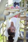 Girl climbing on monkey bars on playground — Stock Photo
