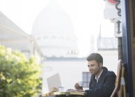 Бизнесмен пьет кофе в кафе на тротуаре возле базилики Сакре Кер, Париж, Франция — стоковое фото