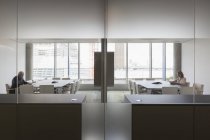 Geschäftsleute, die in modernen symmetrischen Konferenzräumen arbeiten — Stockfoto