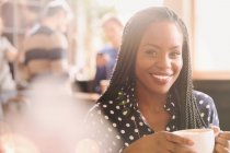 Ritratto sorridente donna africana che beve cappuccino nel caffè — Foto stock