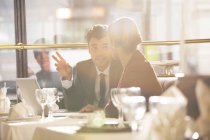 Молодые бизнесмены разговаривают в ресторане — стоковое фото