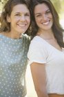 Happy beautiful mother and daughter smiling together outdoors — Stock Photo