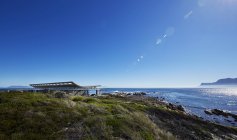 Casa de lujo con vista al mar bajo el soleado cielo azul - foto de stock