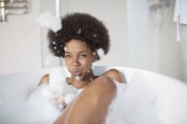 Woman playing with bubbles in bath at home — Stock Photo