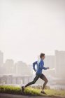 Male runner running on sunny urban city street — Stock Photo