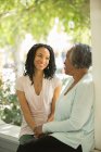Mother and daughter talking on porch — Stock Photo