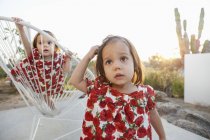 Девочки-близнецы играют на патио — стоковое фото