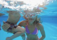 Madre e figlio nuotare sott'acqua in piscina — Foto stock