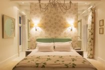 Luxury bedroom with illuminated sconces — Stock Photo