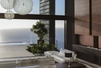 Диваны и столы в современной гостиной с видом на океан — стоковое фото