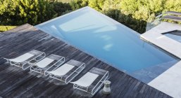 Moderna terraza de lujo con tumbonas y piscina - foto de stock