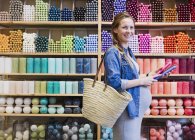 Portrait smiling pregnant woman shopping for candles in shop — Stock Photo