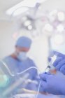 Gros plan anesthésiste injectant des médicaments d'anesthésie dans IV goutte à goutte dans la salle d'opération — Photo de stock