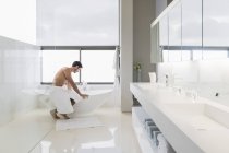 Красивый мужчина в полотенце готовит ванну дома — стоковое фото