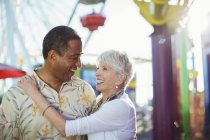 Senior couple hugging at amusement park — Stock Photo