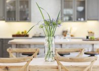 Fleurs en vase sur table en bois — Photo de stock