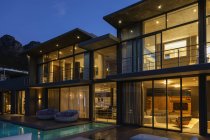 Casa de luxo com piscina iluminada à noite — Fotografia de Stock