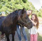 Madre e figlia petting cavallo all'aperto — Foto stock