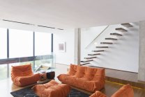 Диваны и лестница в современной гостиной — стоковое фото