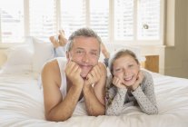 Padre e figlia sdraiati sul letto — Foto stock