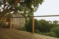 Дом на дереве за деревянной палубой — стоковое фото