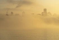 Niebla sobre el horizonte de la ciudad durante el día - foto de stock