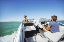 Homem barco de direção na água com a namorada — Fotografia de Stock