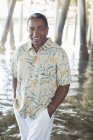 Retrato de homem sênior confiante sob o cais na praia — Fotografia de Stock