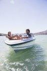Pareja sentados juntos en barco en el agua - foto de stock