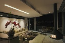 Cheminée de luxe moderne et salle de séjour maison vitrine la nuit — Photo de stock