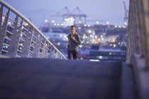 Corridore donna che corre sul ponte pedonale urbano all'alba — Foto stock
