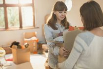 Young women moving packing boxes — Stock Photo