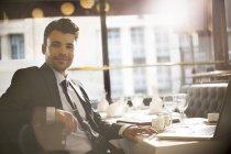 Молодой привлекательный бизнесмен улыбается в ресторане — стоковое фото