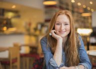Щаслива молода жінка посміхається в кафе — стокове фото