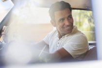 Feliz hombre moderno conduciendo coche en día soleado - foto de stock