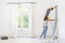 Couple hanging wallpaper together — Stock Photo