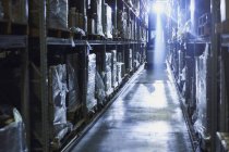 Back lit forklift in distribution warehouse aisle — Stock Photo