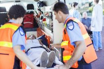 Les ambulanciers examinent le patient en ambulance — Photo de stock